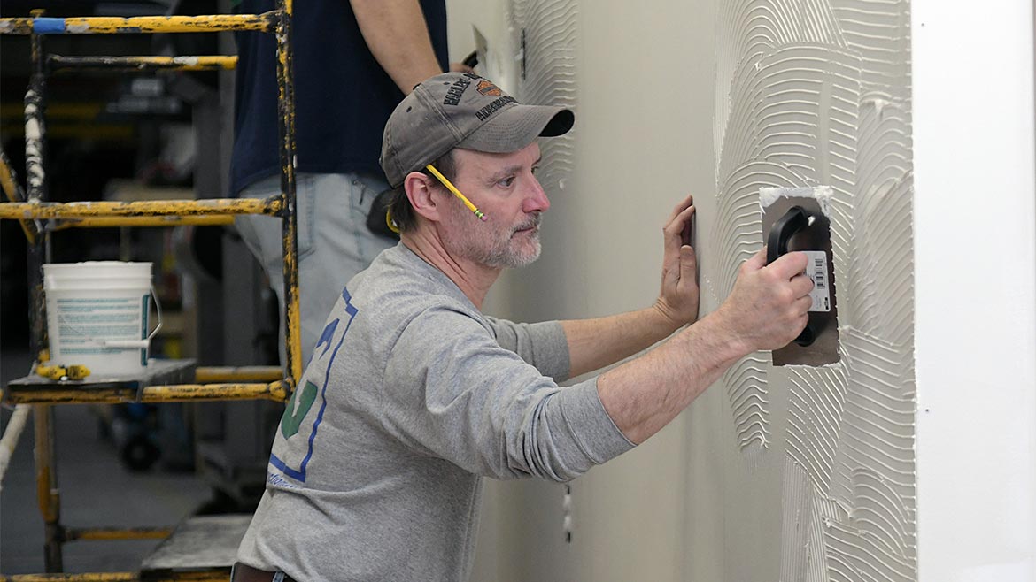 Applying Rigid Sheet Wall Protection Using a trowel to apply Rigid Sheet Wall Protection